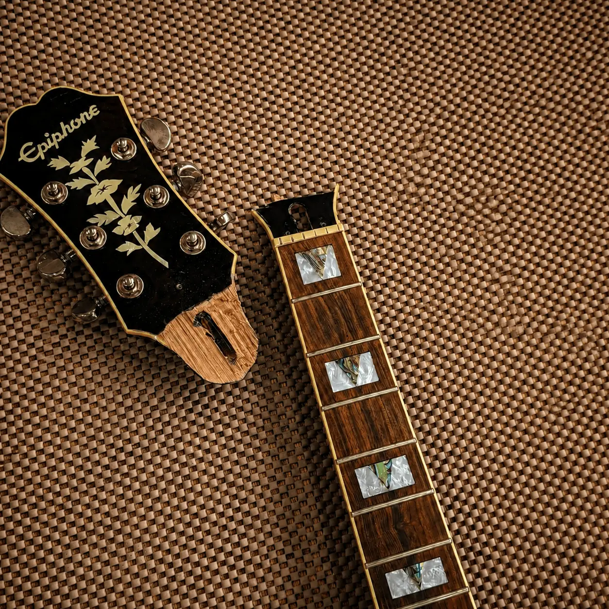 A damaged Epiphone guitar neck prepared for repair